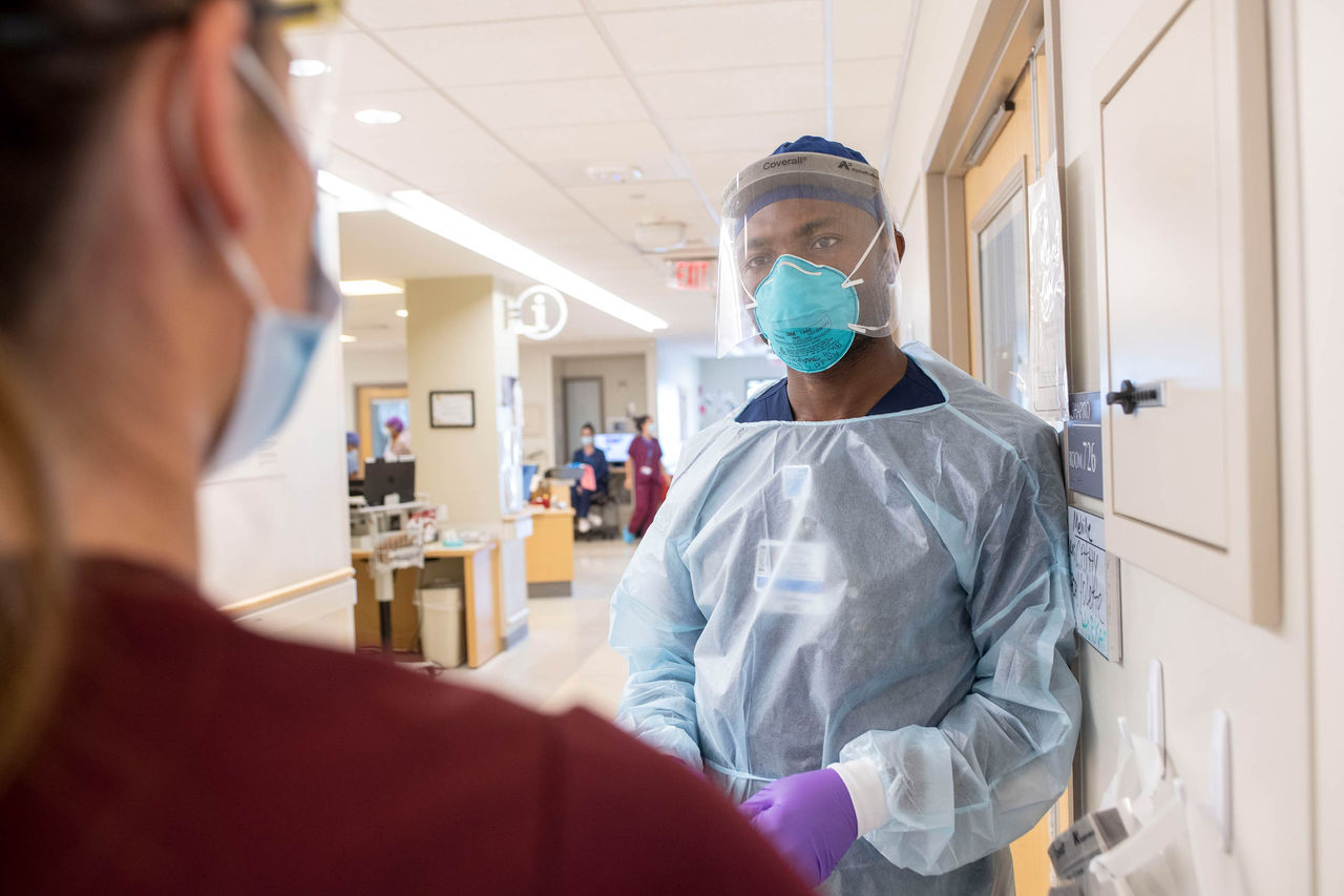 female clinician with mask and face shield in hallway