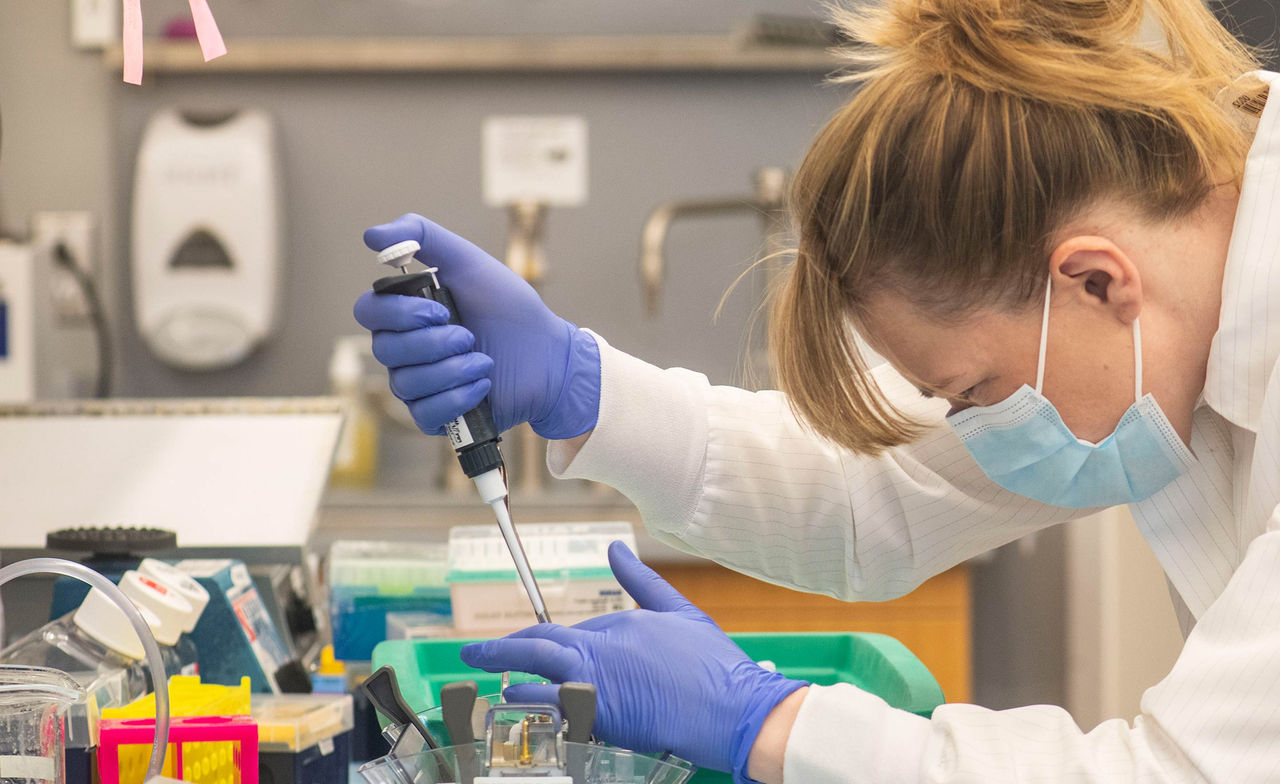 female researcher piping a sample in lab setting