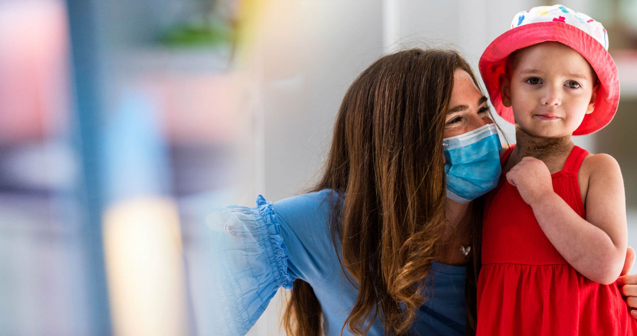female clinician hugging young pediatric patient